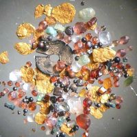 Bild 4  -  Waschkonzentrat unter dem Mikroskop: Goldflitterchen mit abgerollten Granaten, Pyrit, Magnetit, Zirkon, Epidot, Glas und anderem Zivilisationsschutt.